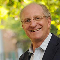 Steven Pearlstien, smiling and standing in the a courtyard on the Mason Fairfax campus.